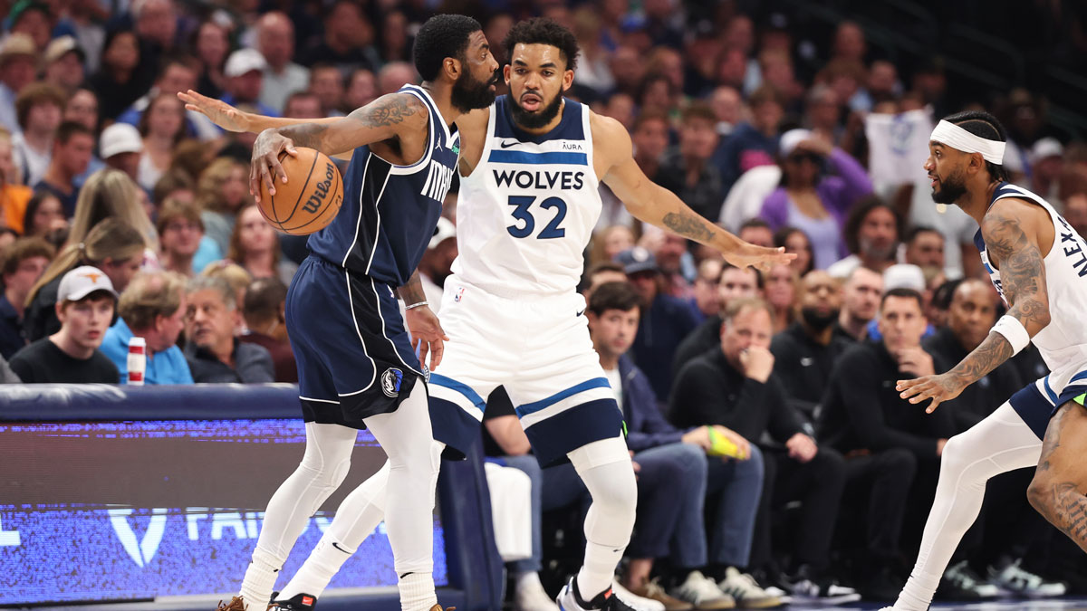 Dallas Mavericks guard Kyrie Irving (11) dribbles against Minnesota Timberwolves center Karl-Anthony Towns (32) during the first quarter of game four of the western conference finals for the 2024 NBA playoffs at American Airlines Center.