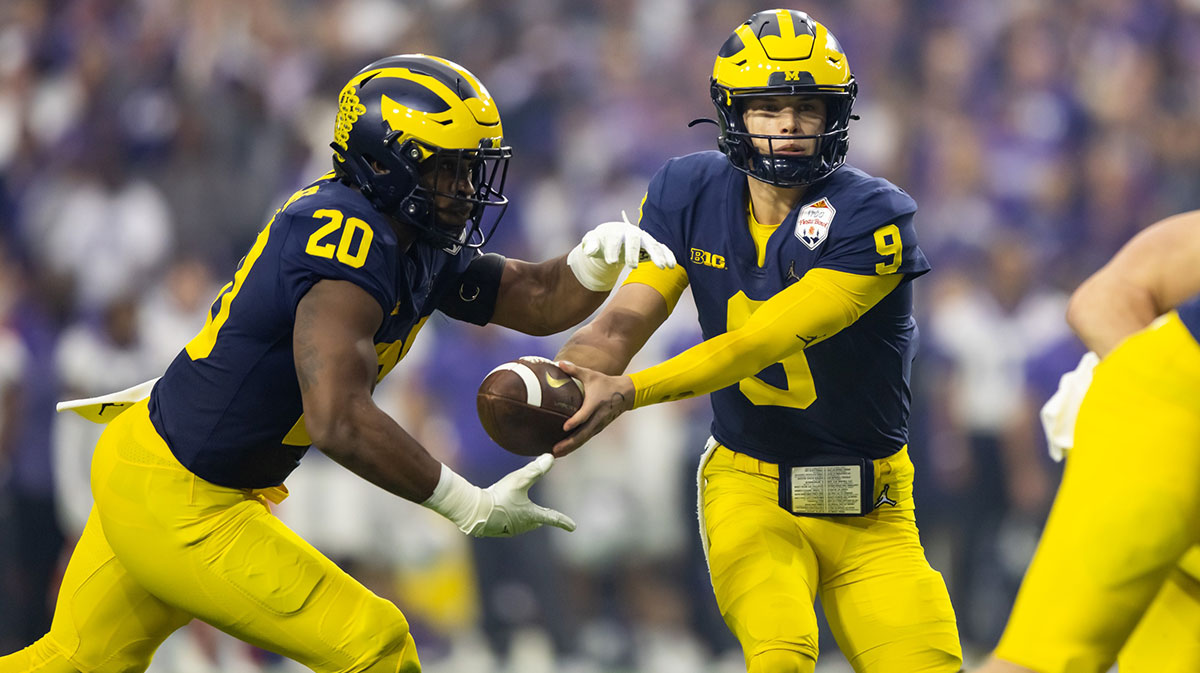 Michigan Wolverines quarterback J.J. McCarthy (9) hands off the ball to running back Kalel Mullings (20) against the TCU Horned Frogs during the 2022 Fiesta Bowl at State Farm Stadium.