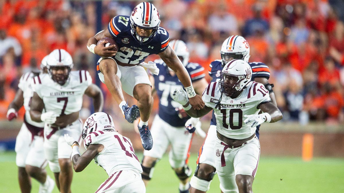 Auburn Tigers running back Jarquez Hunter (27) hurdles Alabama A&M Bulldogs defensive back Elijah Eberhardt (13) as Auburn Tigers takes on Alabama A&M Bulldogs at Jordan-Hare Stadium in Auburn, Ala., on Saturday, Aug. 31, 2024