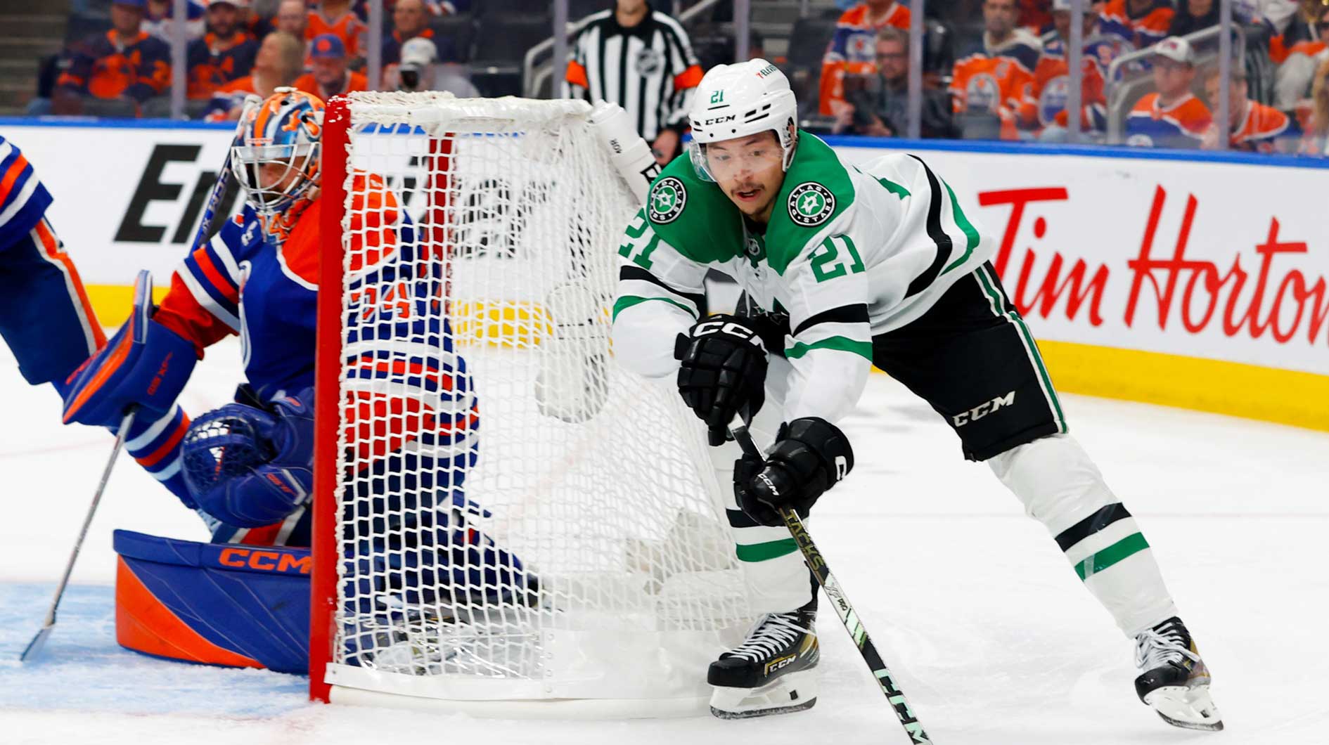 Dallas Stars left wing Jason Robertson (21) skates with the puck behind Edmonton Oilers goaltender Stuart Skinner (74) during the second period in game three of the Western Conference Final of the 2025 Stanley Cup Playoffs at Rogers Place.