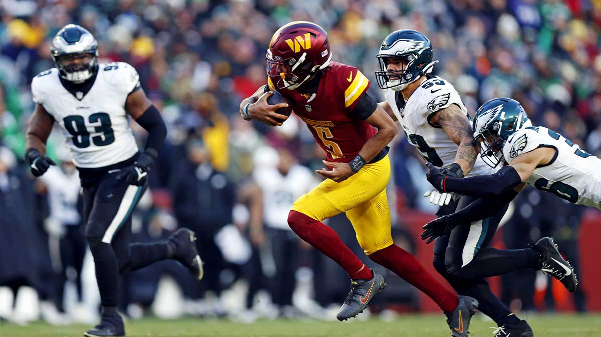 Washington Commanders quarterback Jayden Daniels (5) runs the ball against Philadelphia Eagles linebacker Zack Baun (53) during the fourth quarter at Northwest Stadium.