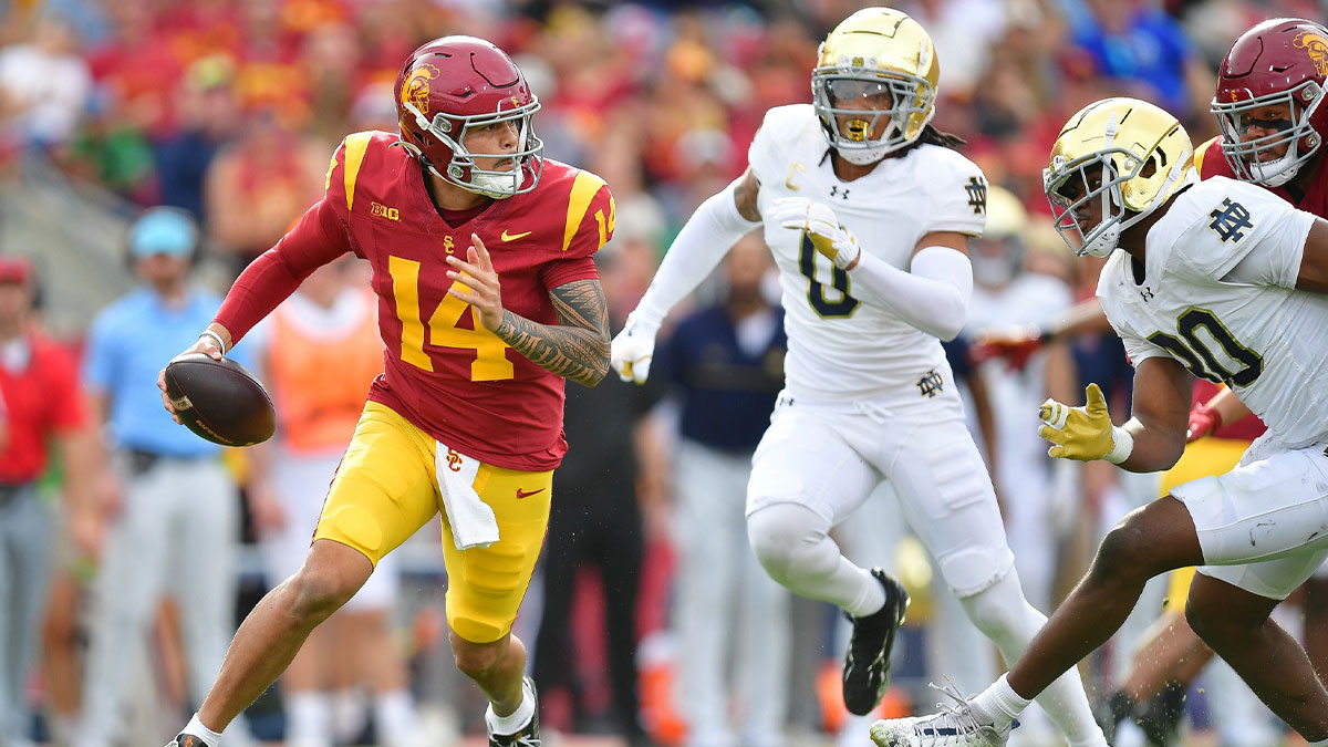 Southern California Trojans quarterback Jayden Maiava (14) runs the ball as Notre Dame Fighting Irish safety Xavier Watts (0) and defensive lineman Bryce Young (30) move in during the first half at the Los Angeles Memorial Coliseum.