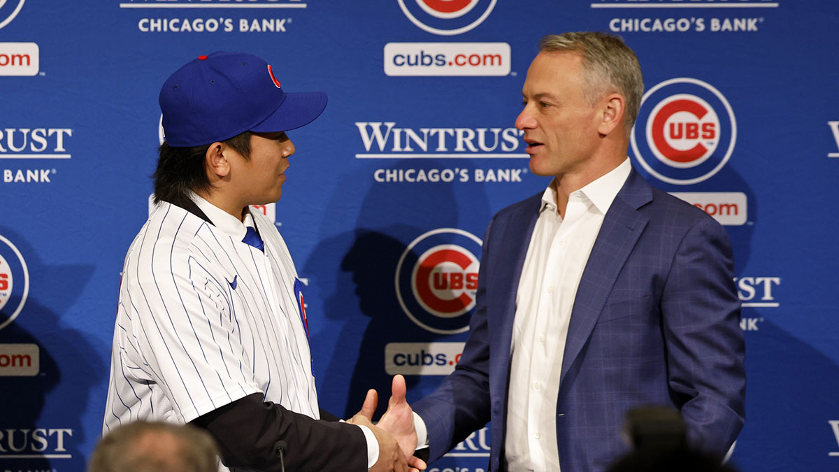 Chicago Cubs president of baseball operations Jed Hoyer (right) shakes hands with newly signed pitcher Shota Imanaga during a press conference.