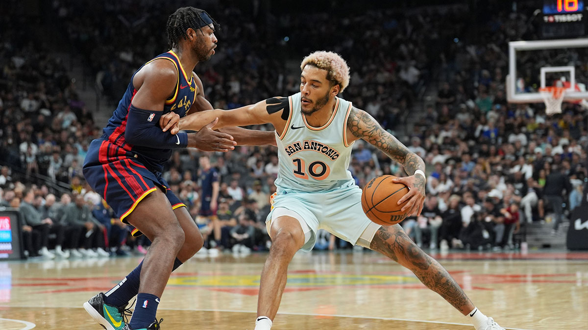 San Antonio Spurs forward Jeremy Sochan (10) dribbles against Golden State Warriors guard Buddy Hield (7) in the second half at Frost Bank Center.