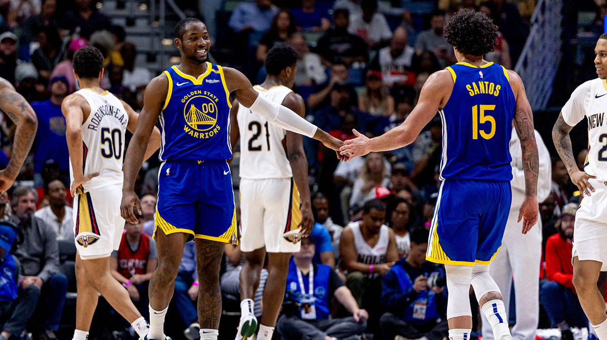 Golden State Warriors forward Jonathan Kuminga (00) slaps hands with forward Gui Santos (15) after a play against the New Orleans Pelicans during the first half at Smoothie King Center.
