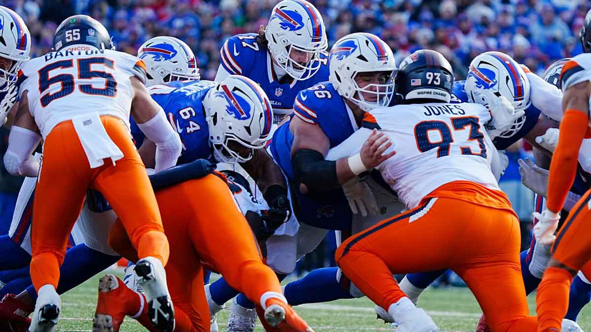 Buffalo Bills quarterback Josh Allen (17) carries the ball across the line of scrimmage for a first down during the first half of the Buffalo Bills wild card game against the Denver Broncos at Highmark Stadium