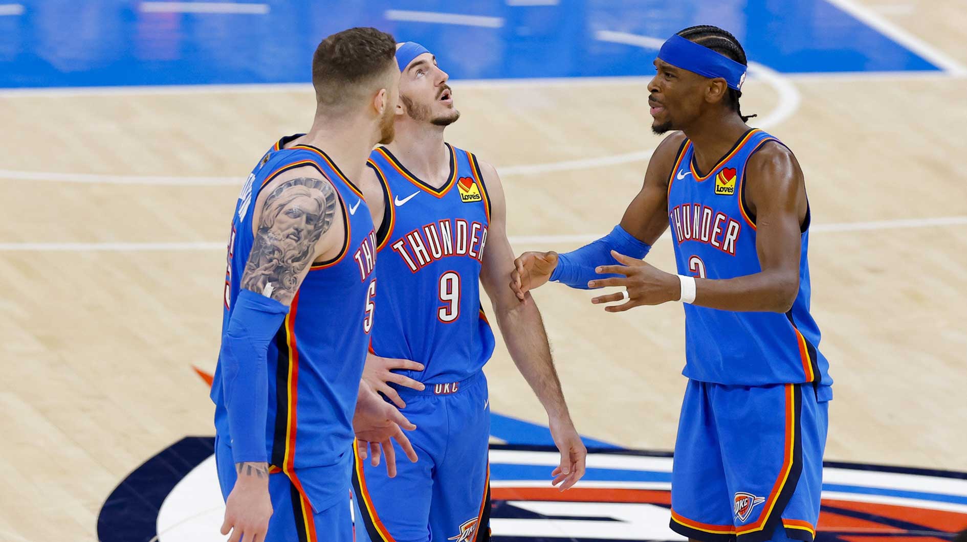 Oklahoma City Thunder center Isaiah Hartenstein (55) and guard Alex Caruso (9) and guard Shai Gilgeous-Alexander (2) talk during the third quarter against the Indiana Pacers in game two of the 2025 NBA Finals at Paycom Center.