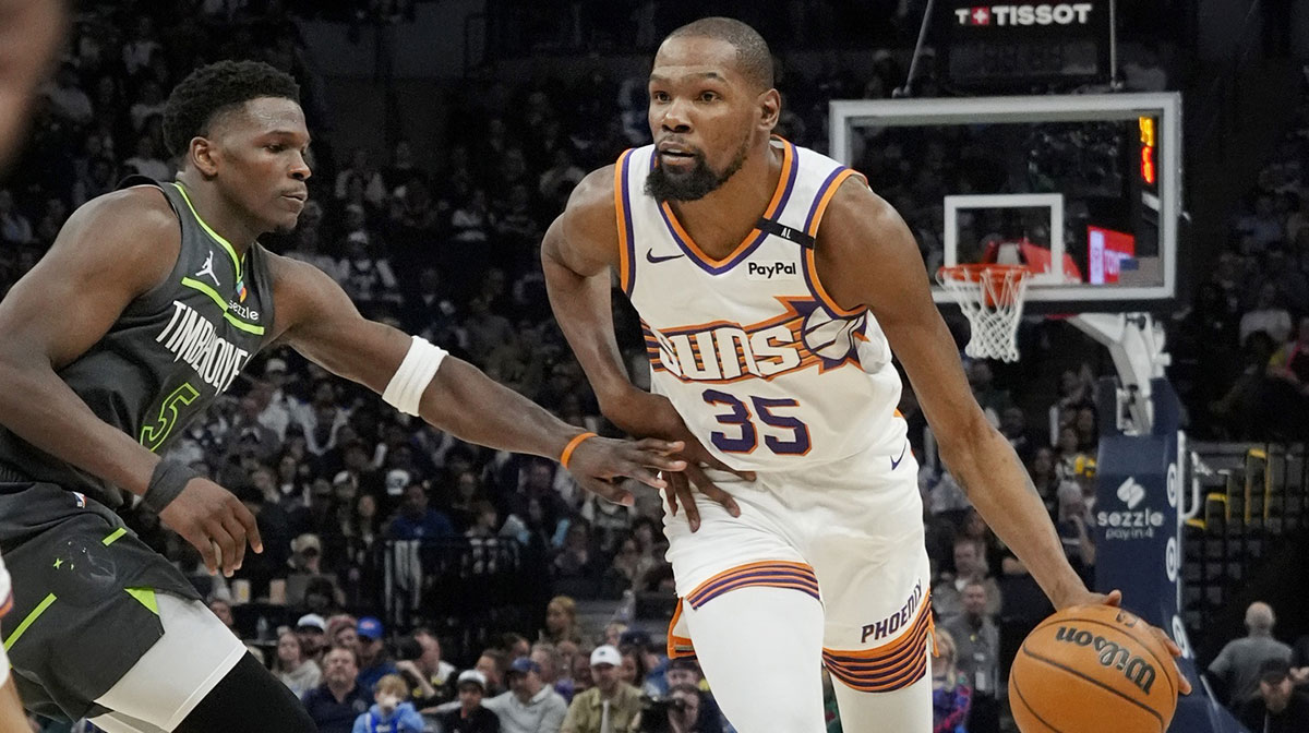 Phoenix Suns forward Kevin Durant (35) brings the ball up as Minnesota Timberwolves guard Anthony Edwards (5) defends him in the fourth quarter at Target Center.