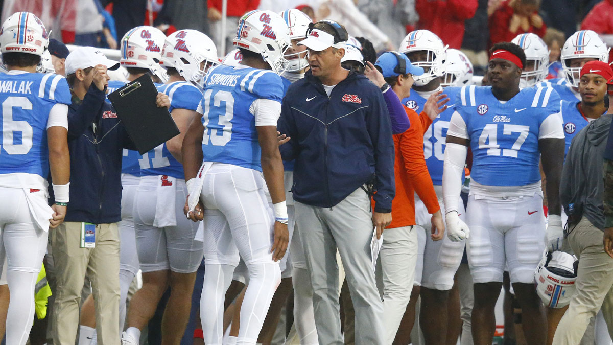 Mississippi Rebels head coach Lane Kiffin talks with quarterback Austin Simmons (13) after a touchdown during the first half against the Georgia Bulldogs at Vaught-Hemingway Stadium.