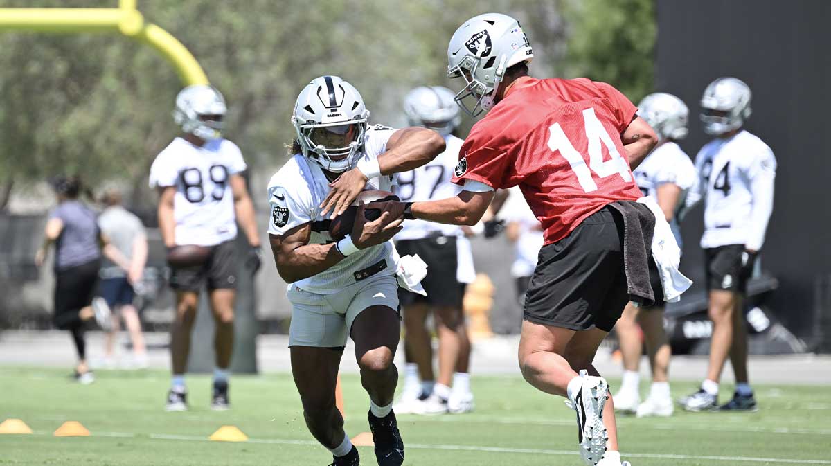 Las Vegas Raiders quarterback Carter Bradley (14) hands the ball to running back Ashton Jeanty (2) during Las Vegas Raiders Minicamp at Intermountain Health Performance Center.