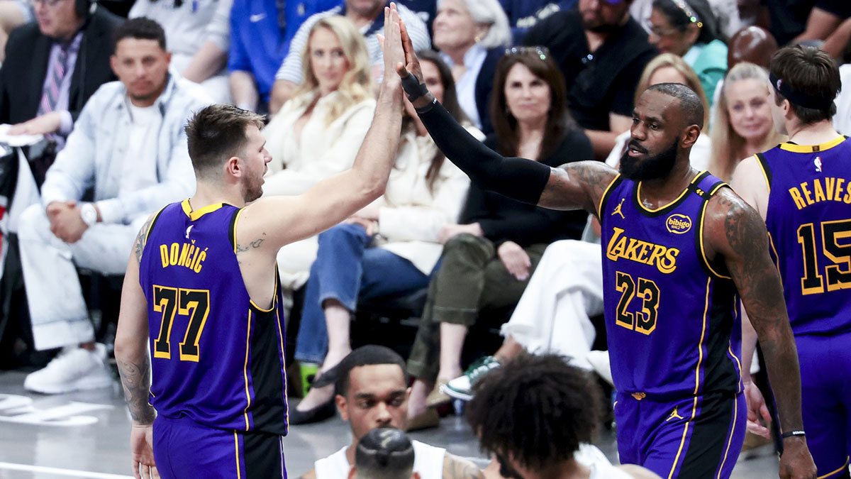 Los Angeles Lakers guard Luka Doncic (77) celebrates with Los Angeles Lakers forward LeBron James (23) during the fourth quarter against the Dallas Mavericks at American Airlines Center.