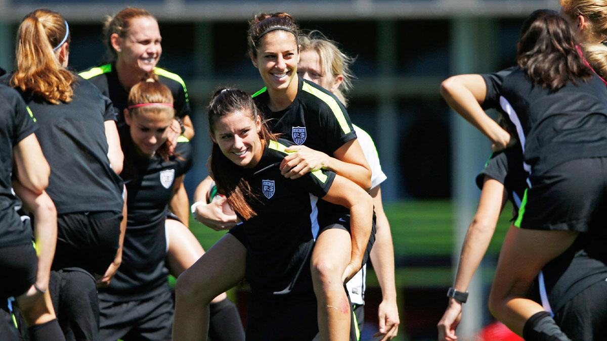 United States defender Ali Krieger (center) carries midfielder Carli Lloyd while playing a game during a training session for the 2015 Women's World Cup at Empire Field South.