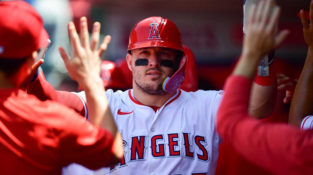 Los Angeles Angels designated hitter Mike Trout (27) is greeted after scoring a run against the Athletics during the sixth inning at Angel Stadium.