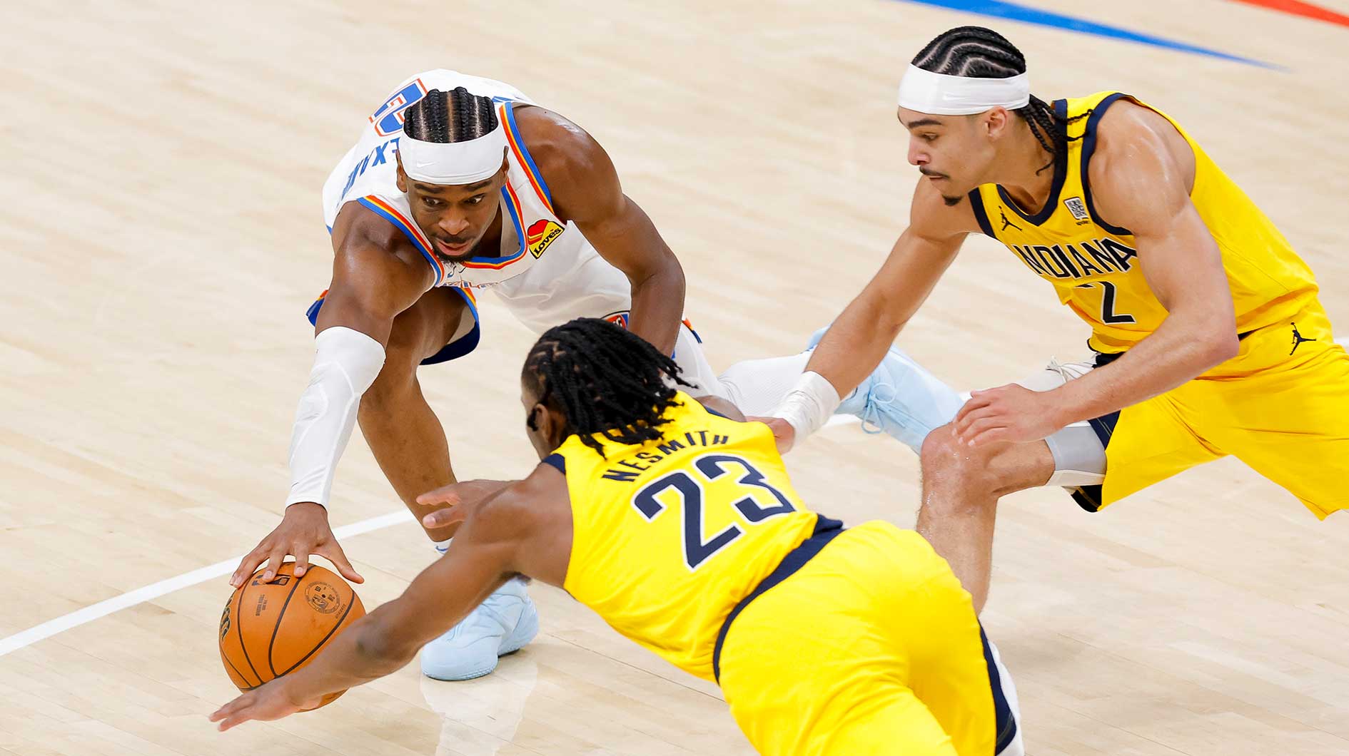 Oklahoma City Thunder guard Shai Gilgeous-Alexander (2) and Indiana Pacers forward Aaron Nesmith (23) and guard Andrew Nembhard (2) battle for the loose ball during the fourth quarter during game one of the 2025 NBA Finals at Paycom Center.