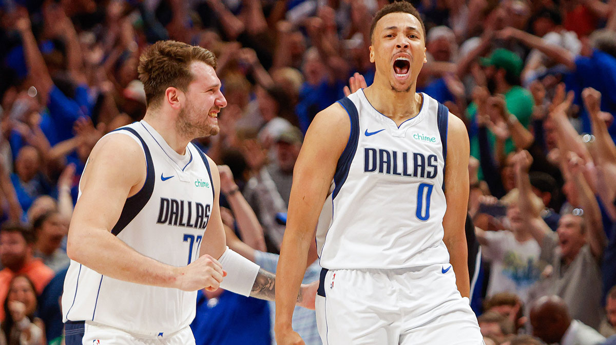 Dallas Mavericks guard Luka Doncic (77) celebrates with guard Dante Exum (0) after a three-point basket at the end of regulation against the Houston Rockets at American Airlines Center.