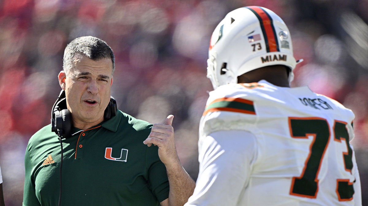 Miami Hurricanes head coach Mario Cristobal talks with offensive lineman Anez Cooper (73) during the first half against the Louisville Cardinals at L&N Federal Credit Union Stadium.