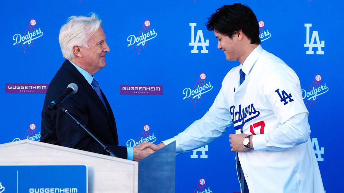 Los Angeles Dodgers player Shohei Ohtani shakes hands with Dodgers owner Mark Walter at an introductory press conference at Dodger Stadium.