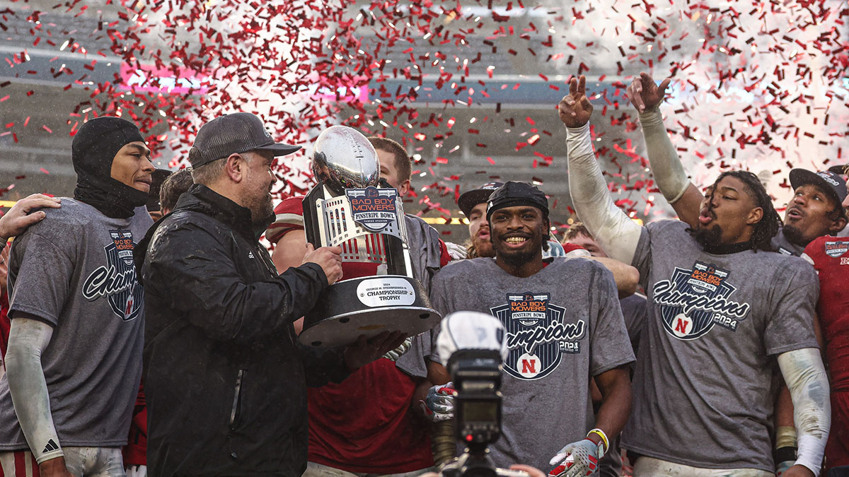 Nebraska Cornhuskers head coach Matt Rhule holds the championship trophy as Cornhuskers players celebrate after the game against the Boston College Eagles at Yankee Stadium.