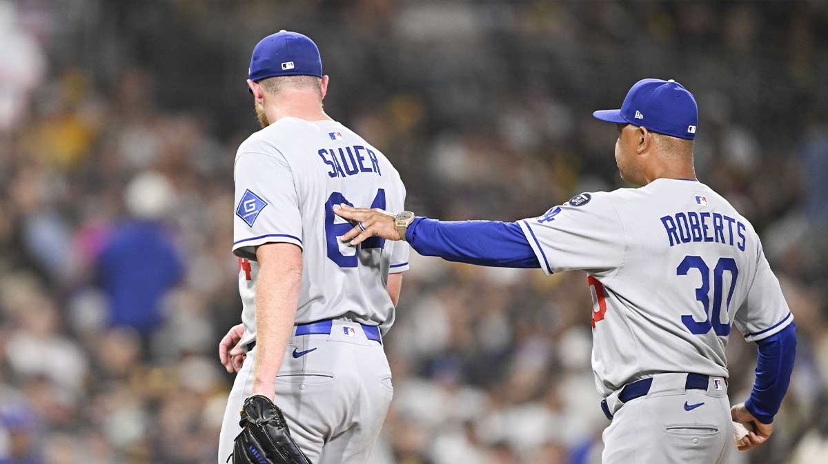 Los Angeles Dodgers manger Dave Roberts helps Matt Sauer (64) off the field during the sixth inning against the San Diego Padres at Petco Park.