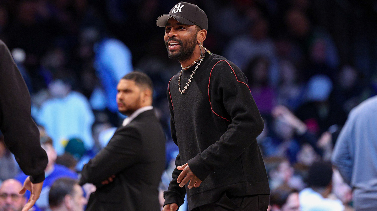 Mavericks guard Kyrie Irving (11) looks on during the first quarter against the Brooklyn Nets at Barclays Center with ESPN's Shams Charania in the background