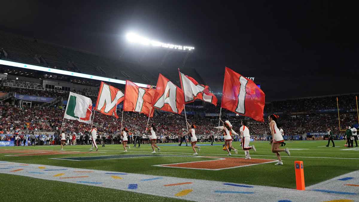Miami Hurricanes cheerleaders run on the field with flags after a touchdown against the Iowa State Cyclones during the second half at Camping World Stadium.