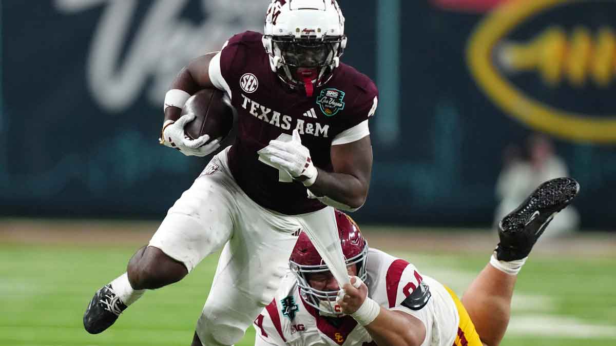 Texas A&M Aggies wide receiver Micah Tease (4) carries the ball against Southern California Trojans defensive tackle Kobe Pepe (94) in the second half at Allegiant Stadium.