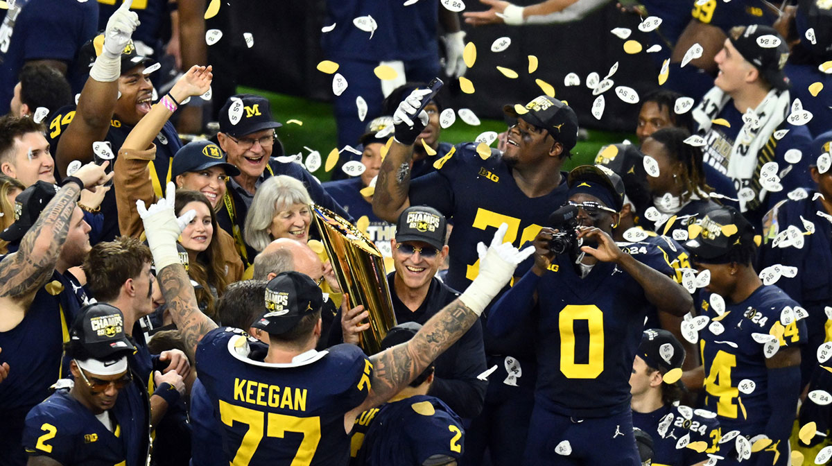 Michigan Wolverines head coach Jim Harbaugh holds the National Championship Trophy as he celebrates after winning 2024 College Football Playoff national championship game against the Washington Huskies at NRG Stadium.