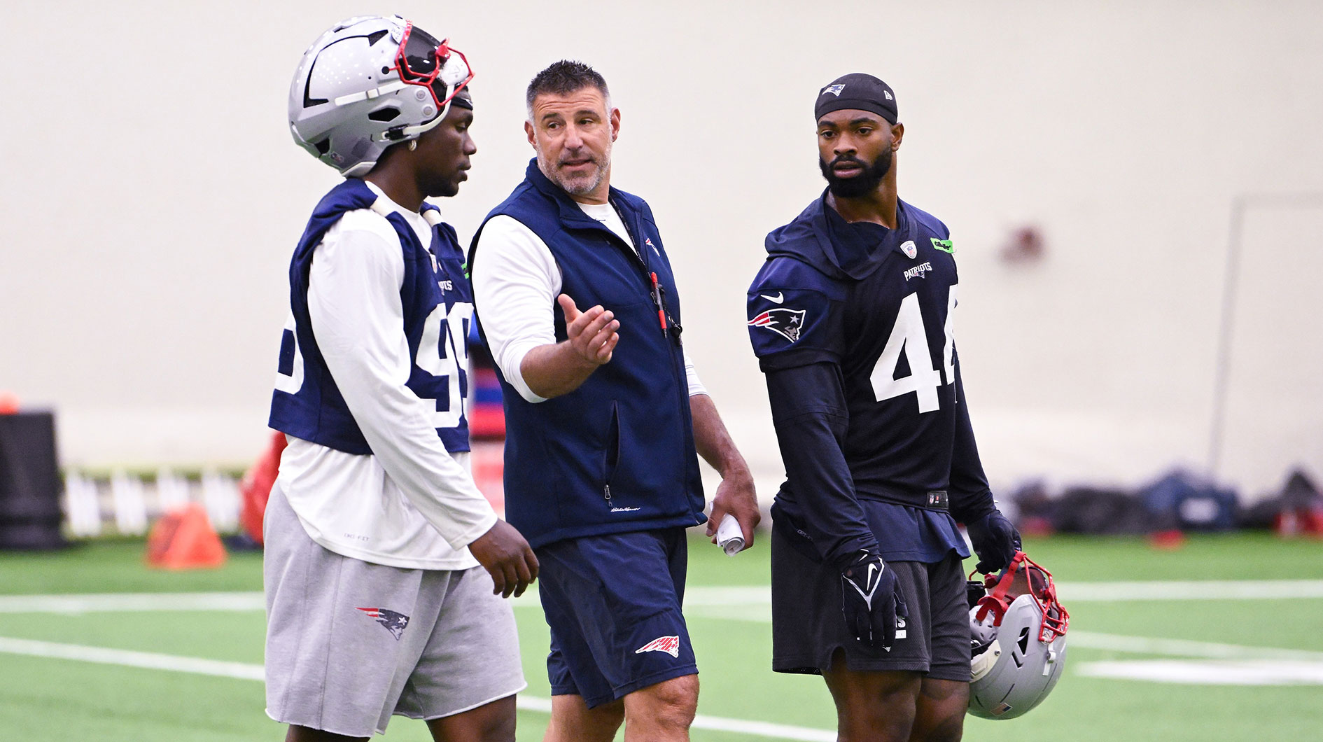 New England Patriots head coach Mike Vrabel speaks to defensive end Keion White (99) and linebacker K'Lavon Chaisson (44) after minicamp held in the WIN Field House at Gillette Stadium.