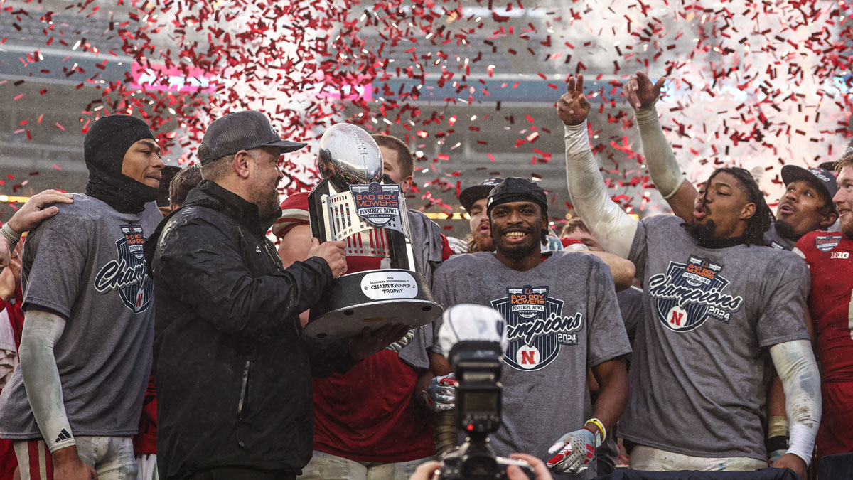 Nebraska Cornhuskers head coach Matt Rhule holds the championship trophy as Cornhuskers players celebrate after the game against the Boston College Eagles at Yankee Stadium.