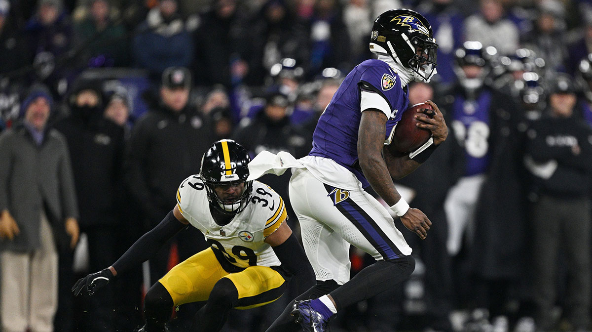 Baltimore Ravens quarterback Lamar Jackson (8) runs against Pittsburgh Steelers safety Minkah Fitzpatrick (39) in the first quarter in an AFC wild card game at M&T Bank Stadium.
