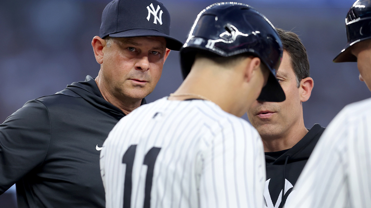 New York Yankees manager Aaron Boone (17) checks on shortstop Anthony Volpe (11) after Volpe was hit by a pitch during the second inning against the Boston Red Sox at Yankee Stadium.
