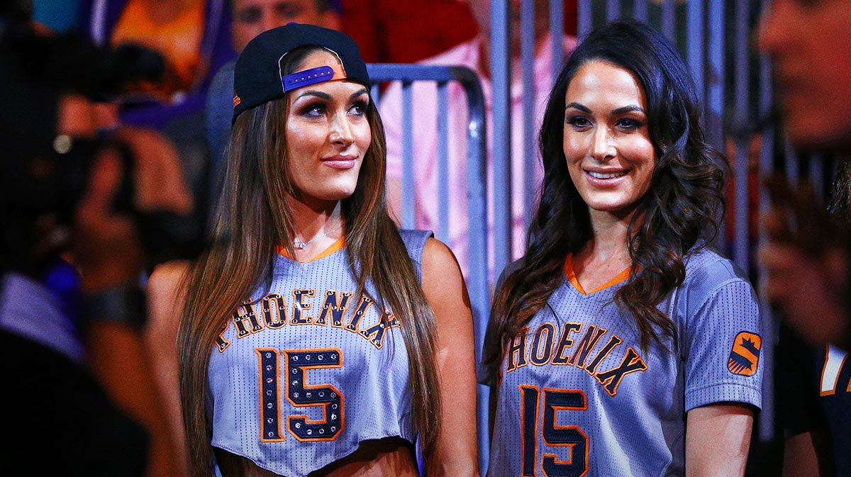 WWE Superstars Nikki and Brie Bella, who may return and reunite at Evolution 2, at Timberwolves-Suns game.