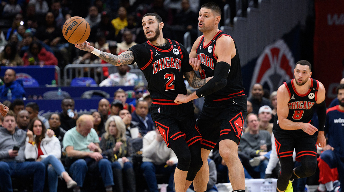 Chicago Bulls guard Lonzo Ball (2) and Chicago Bulls center Nikola Vucevic (9) reach for a loose ball during the third quarter against the Washington Wizards at Capital One Arena.