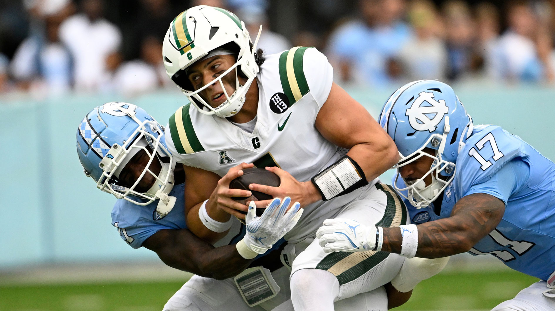 Charlotte 49ers quarterback Max Brown (1) is tackled by North Carolina Tar Heels defensive back Kaleb Cost (21) and linebacker Amare Campbell (17) in the 1st quarter at Kenan Memorial Stadium. Mandatory Credit: Bob Donnan-Imagn Images