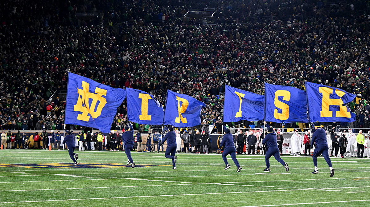 Notre Dame Fighting Irish cheerleaders carry flags across the field during the second half against the Indiana Hoosiers at Notre Dame Stadium.