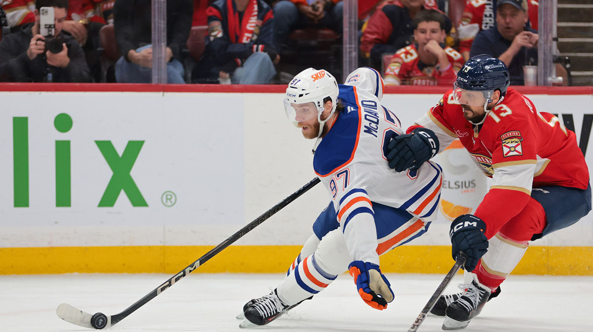 Edmonton Oilers center Connor McDavid (97) controls the puck defended by Florida Panthers center Sam Reinhart (13) during the first period in game six of the 2025 Stanley Cup Final at Amerant Bank Arena.