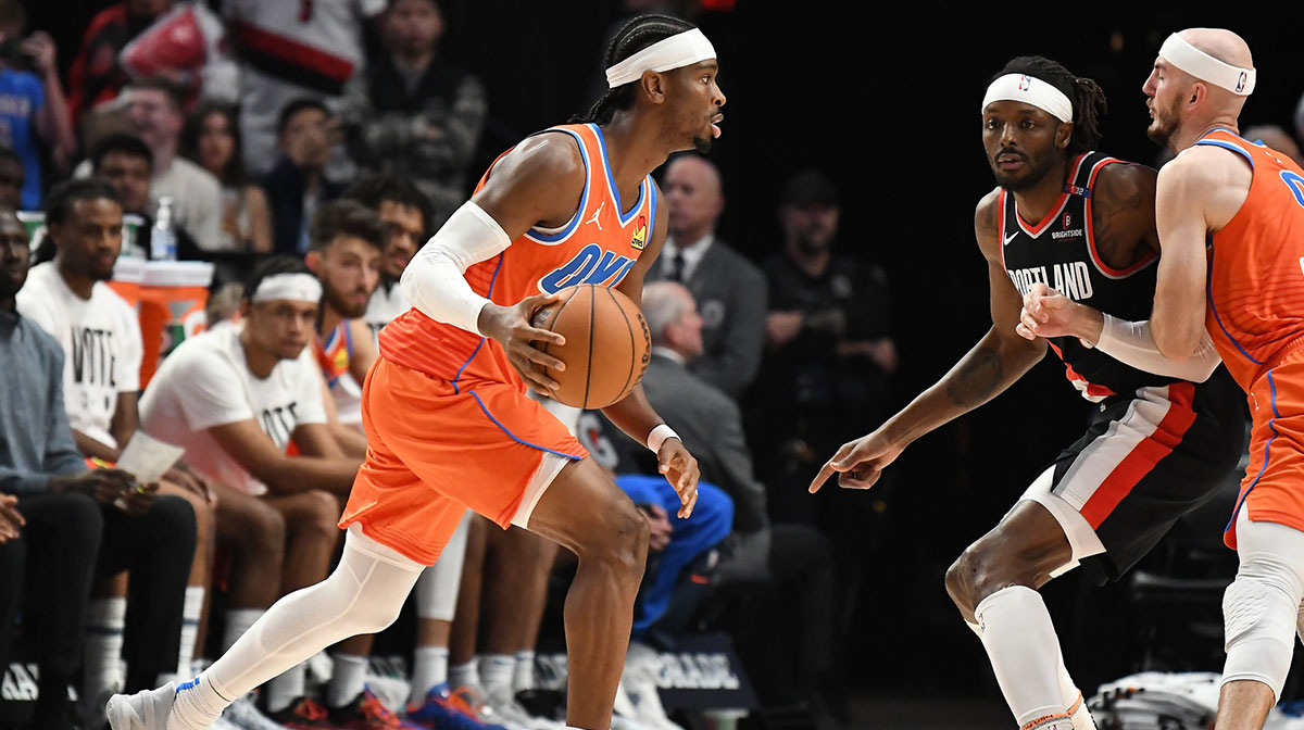 Oklahoma City Thunder guard Shai Gilgeous-Alexander (2) dribbles around a pick set by guard Alex Caruso (9) against Portland Trail Blazers forward Jerami Grant (9) during the third quarter at Moda Center.