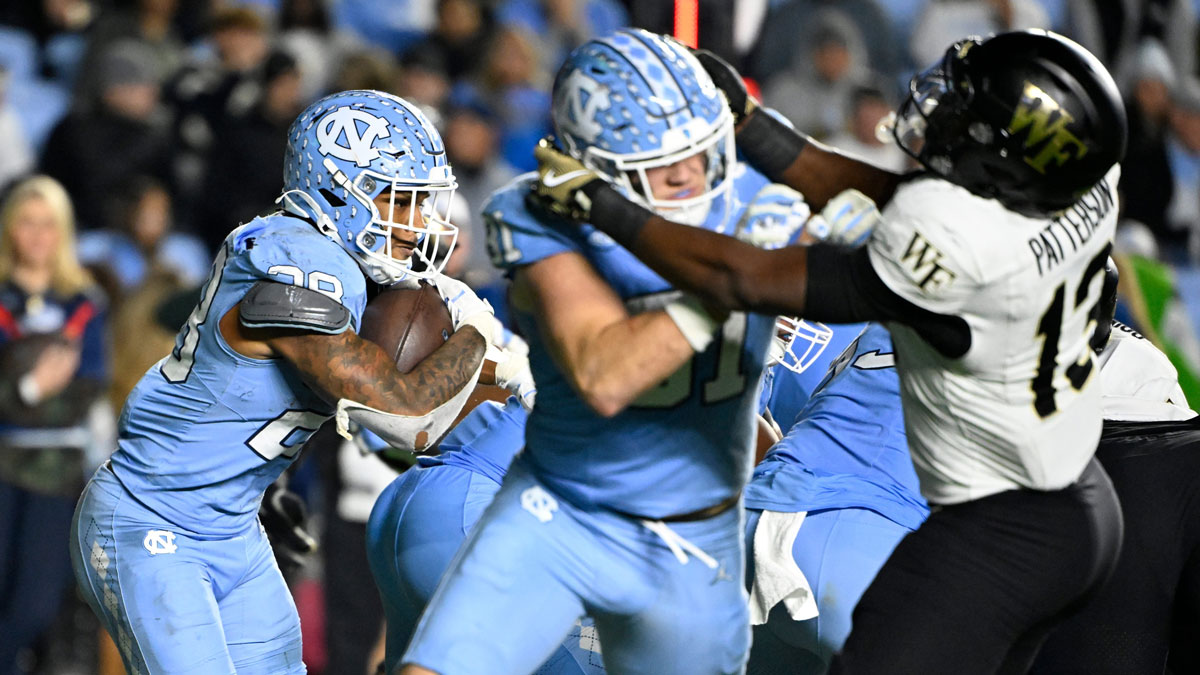 North Carolina Tar Heels running back Omarion Hampton (28) runs as tight end John Copenhaver (81) blocks and Wake Forest Demon Deacons defensive back Davaughn Patterson (13) defends in the fourth quarter at Kenan Memorial Stadium.