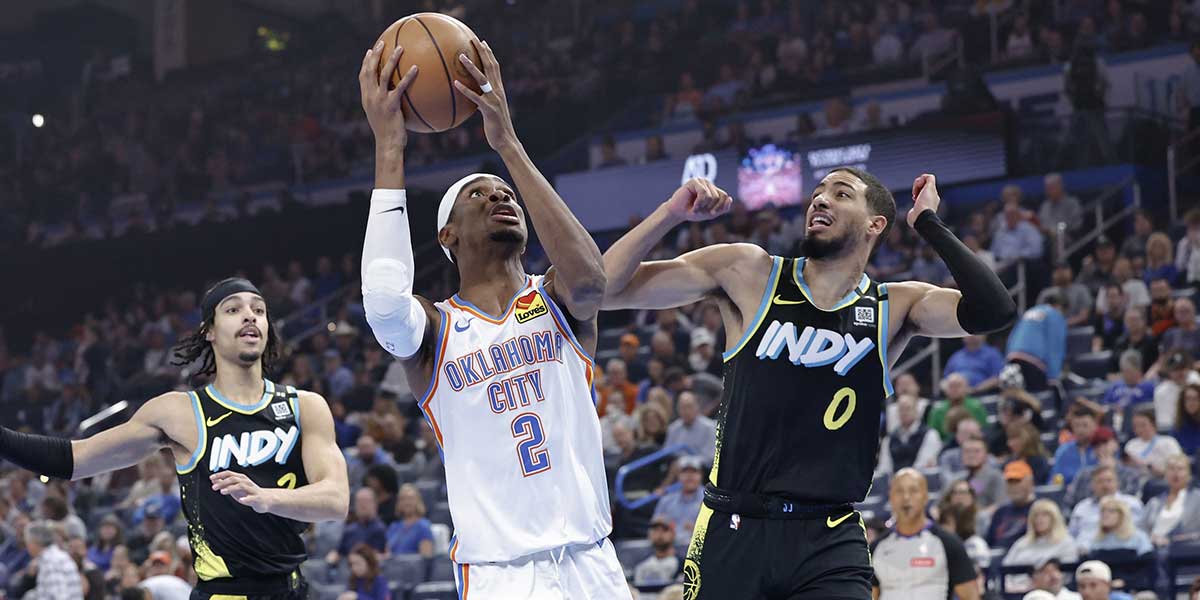 Thunder guard Shai Gilgeous-Alexander (2) drives to the basket beside Indiana Pacers guard Tyrese Haliburton (0) during the first quarter at Paycom Center with Warriors' Stephen Curry and Cavs' Kyrie Irving in the background