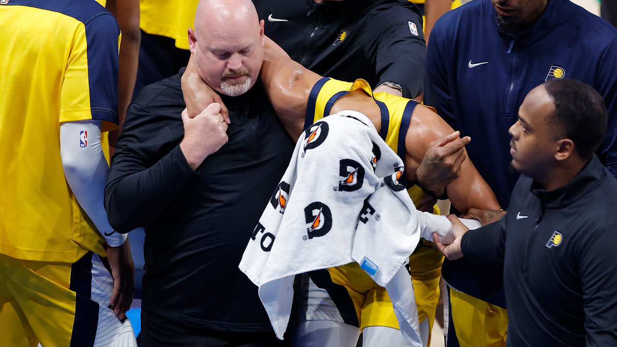 Indiana Pacers guard Tyrese Haliburton (0) is assisted after an apparent injury following a play against the Oklahoma City Thunder during the first half of game seven of the 2025 NBA Finals at Paycom Center.
