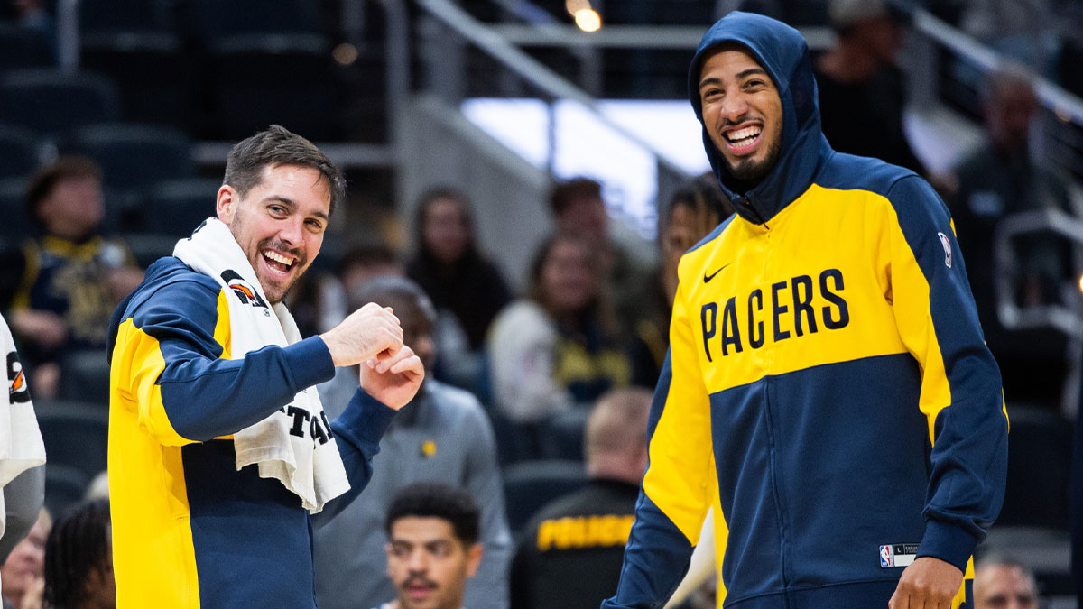 Indiana Pacers guard T.J. McConnell (9) and guard Tyrese Haliburton (0) cheer in the second half against the Charlotte Hornets at Gainbridge Fieldhouse.