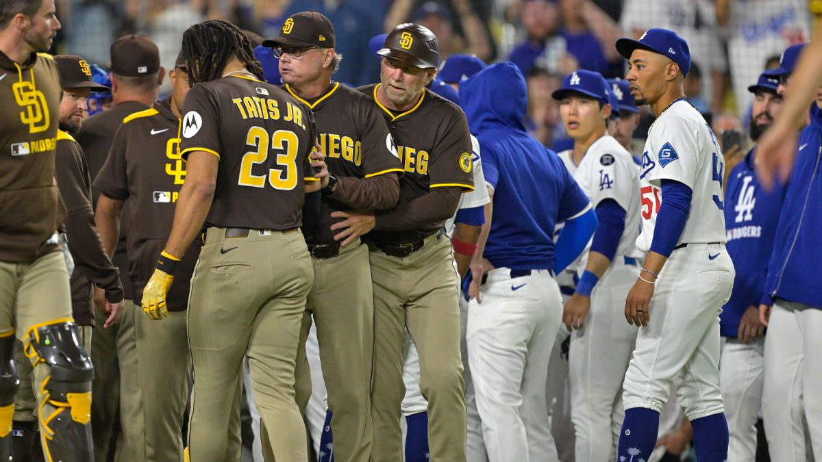 San Diego Padres manager Mike Shildt (8) and third base coach Tim Leiper (33) with San Diego Padres right fielder Fernando Tatis Jr. (23) as Los Angeles Dodgers shortstop Mookie Betts (50) looks on after benches cleared in the eighth inning at Dodger Stadium.