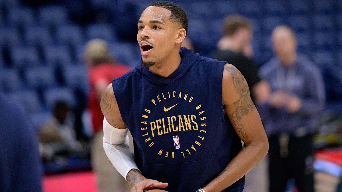 Pelicans guard Dejounte Murray warms up before a game against the Dallas Mavericks at Smoothie King Center with Pelicans' Joe Dumars in the background