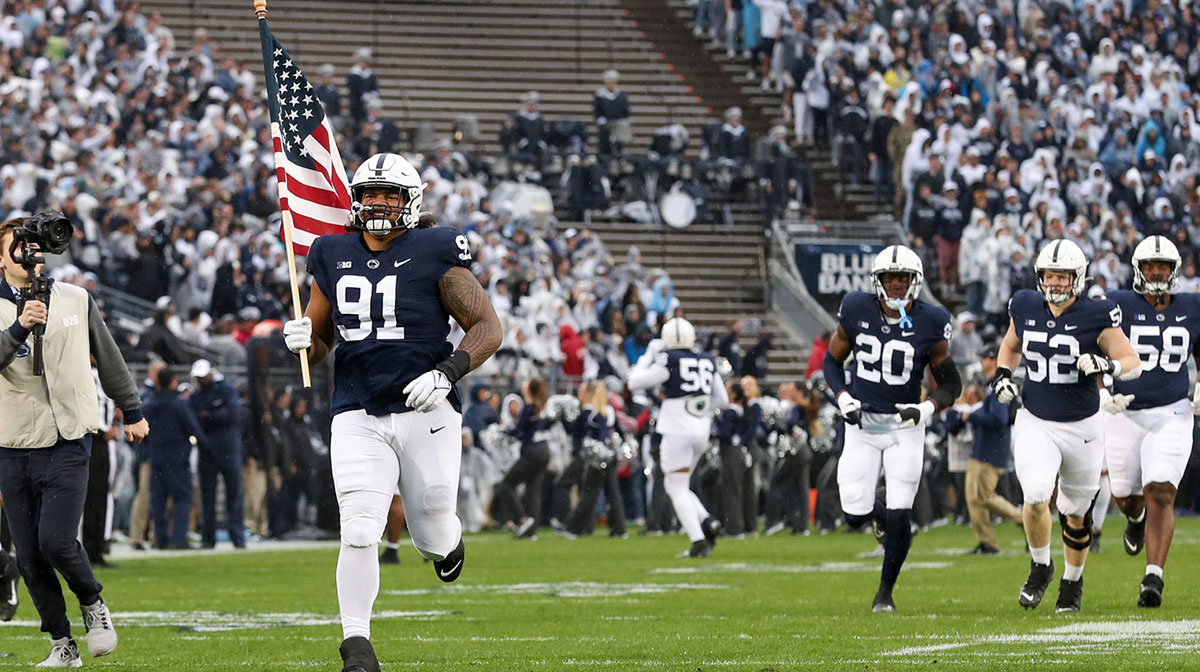Penn State Nittany Lions defensive tackle Dvon Ellies (91) carries the American flag onto the field prior to the game against the Maryland Terrapins at Beaver Stadium.