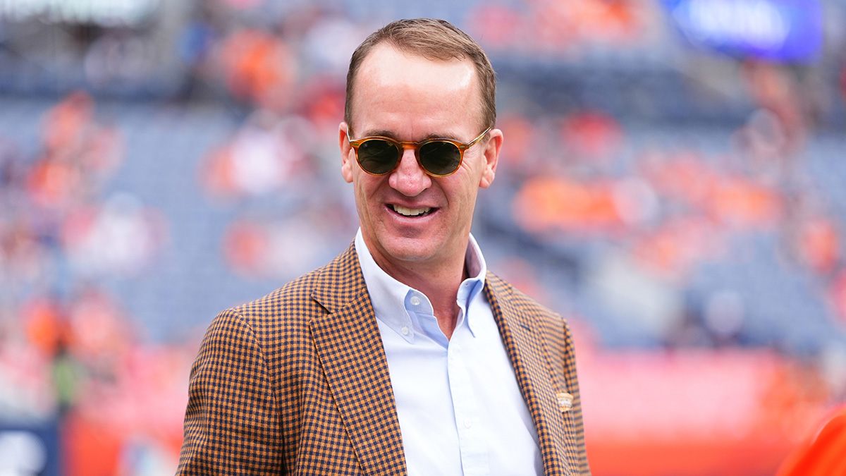 Retired NFL player Peyton Manning stands on the sidelines of Empower Field at Mile High before the game between the Carolina Panthers Denver Broncos.