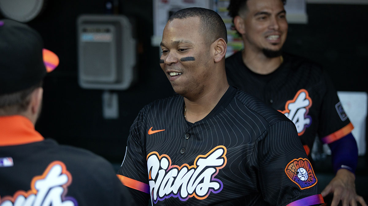 San Francisco Giants designated hitter Rafael Devers (16) greets his new teammates in the dugout before taking on the Cleveland Guardians during the first inning at Oracle Park.