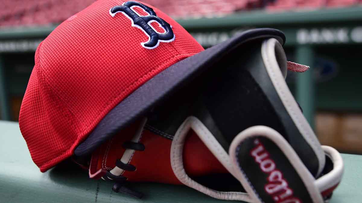 A Boston Red Sox hat and glove rests on the railing by the dugout prior to a game against the Atlanta Braves at Fenway Park.