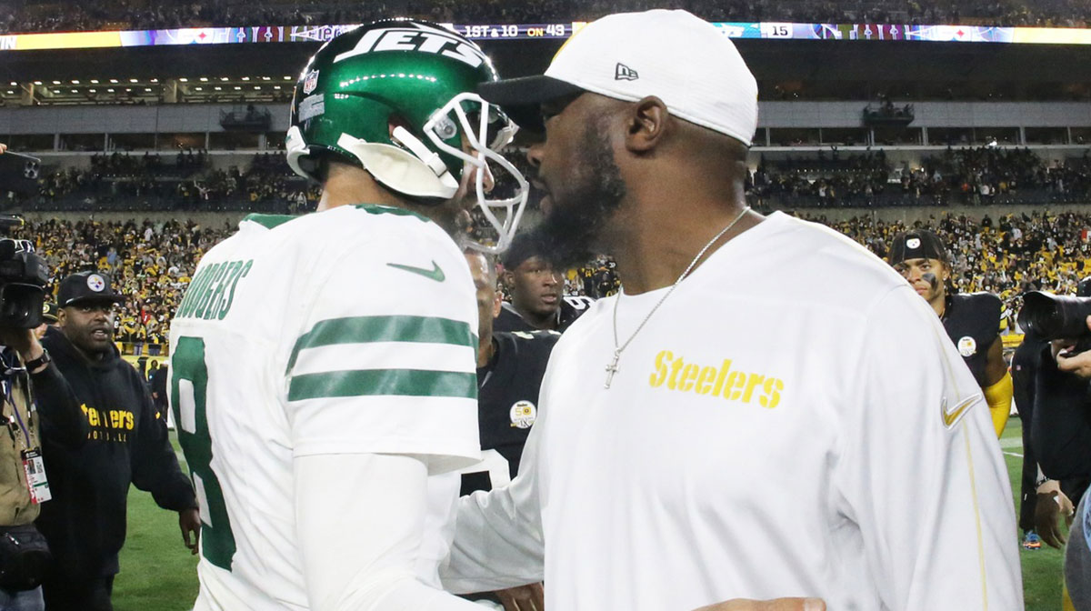 New York Jets quarterback Aaron Rodgers (8) and Pittsburgh Steelers head coach Mike Tomlin (right) greet each other after their game at Acrisure Stadium.