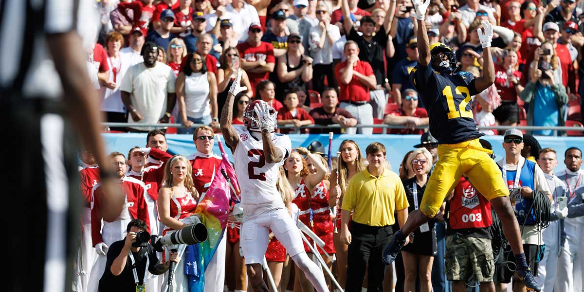 Michigan Wolverines defensive back Aamir Hall (12) attempts to break up a pass to Alabama Crimson Tide wide receiver Ryan Williams (2) during the first half at Raymond James Stadium.