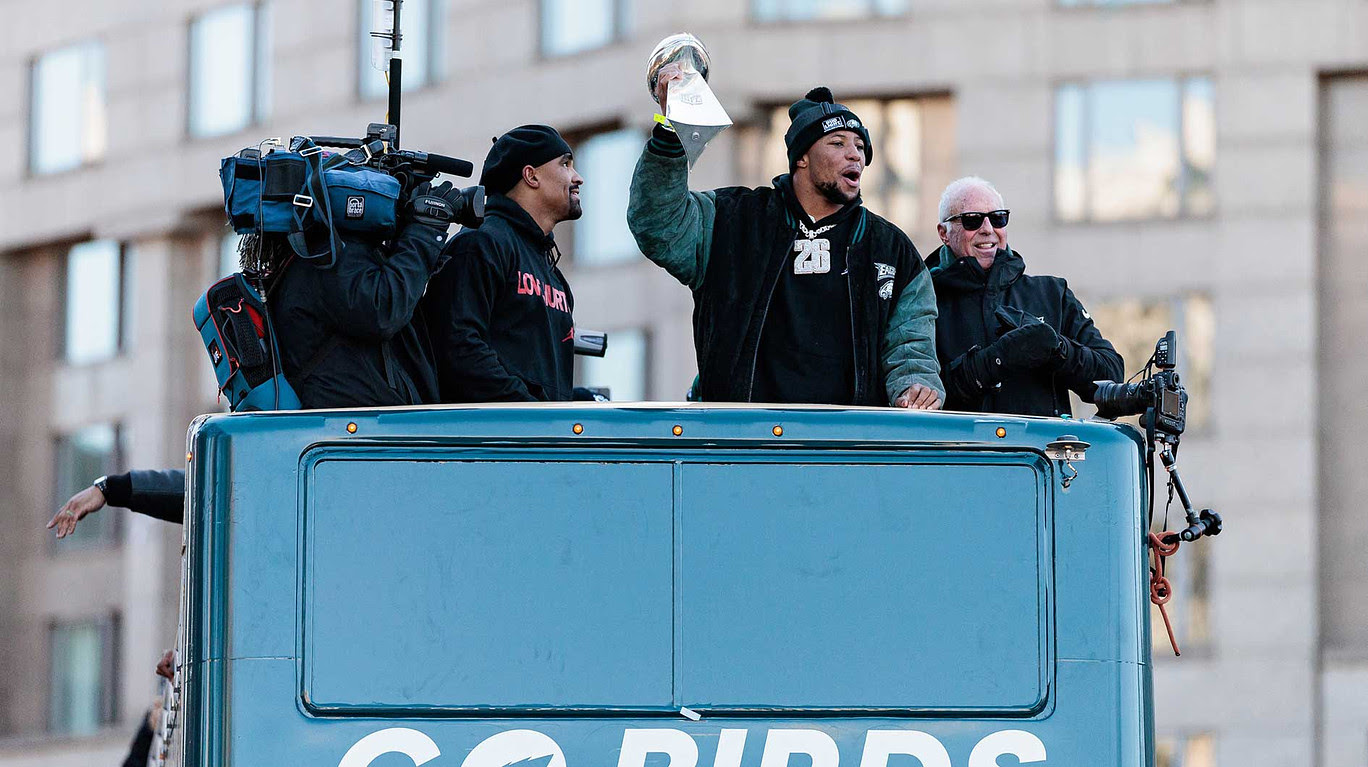 Philadelphia Eagles running back Saquon Barkley (26) celebrates next to team owner Jeffrey Lurie and quarterback Jalen Hurts (1) during the Super Bowl LIX championship parade.